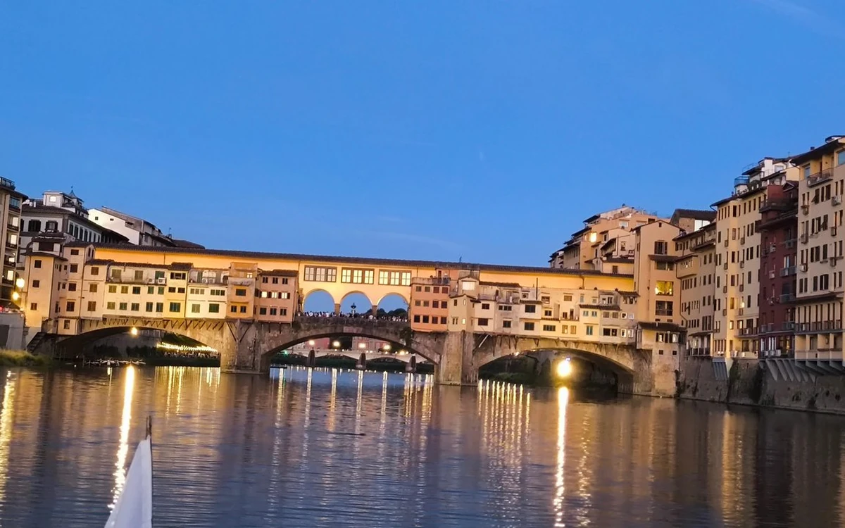 The Ponte Vecchio lit at dusk over the Arno