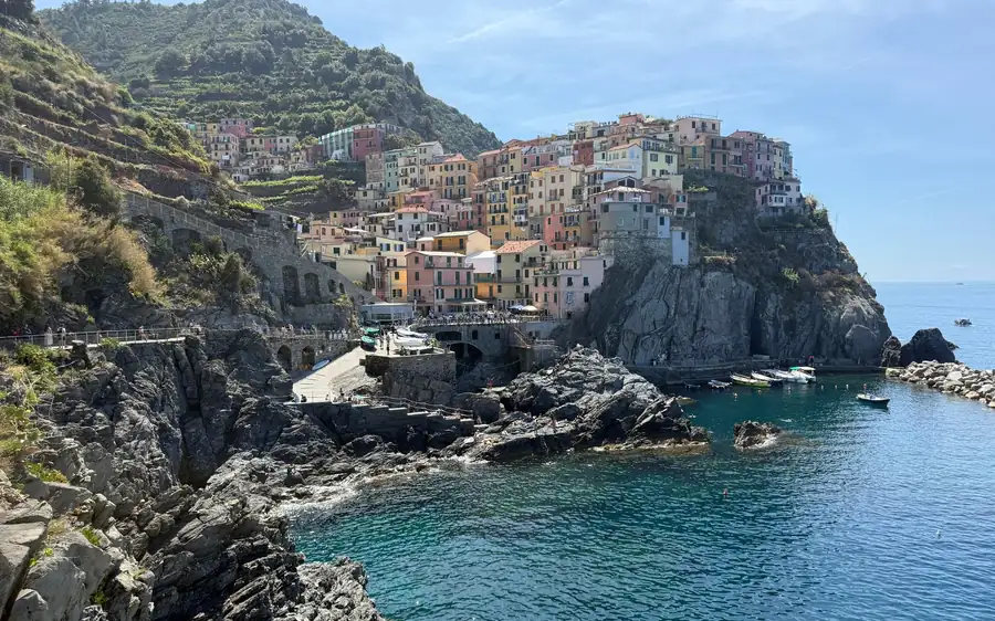 Pastel houses on a rocky headland above clear blue water