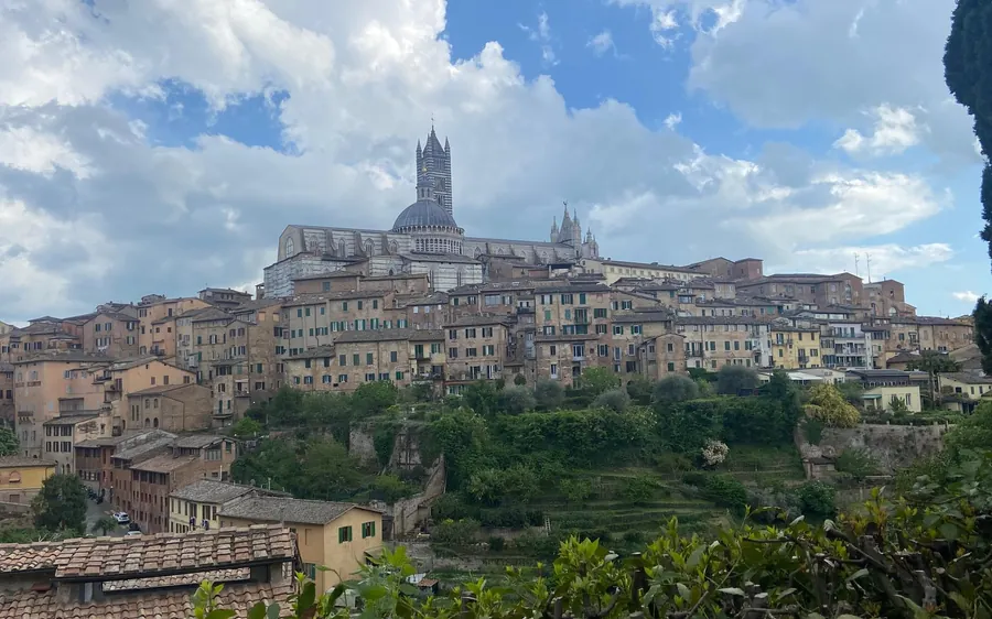 A hill town of brick houses with a striped cathedral on its skyline