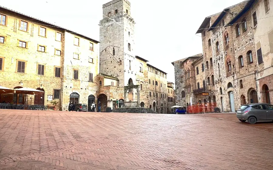 A paved medieval square with a tall stone tower