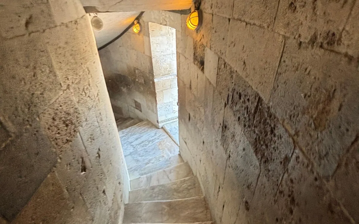 Worn marble steps curving up inside a narrow stone tower