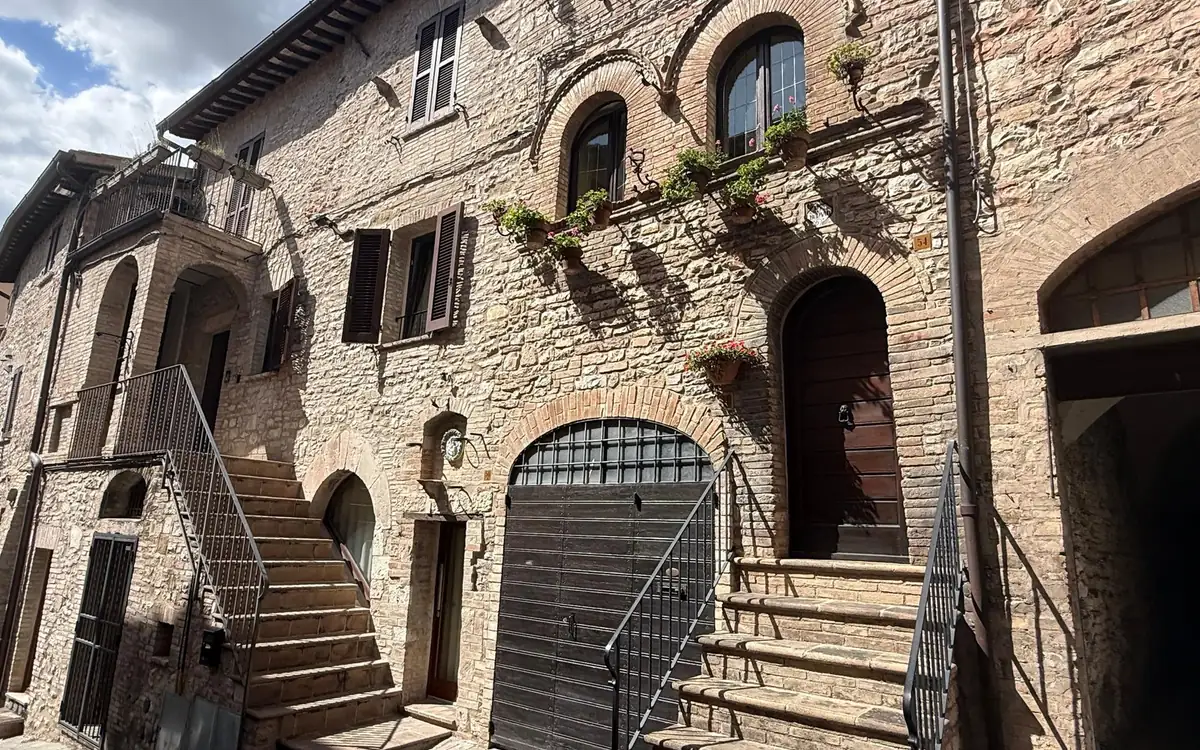 Stone houses with outside stairs and flower pots in Assisi