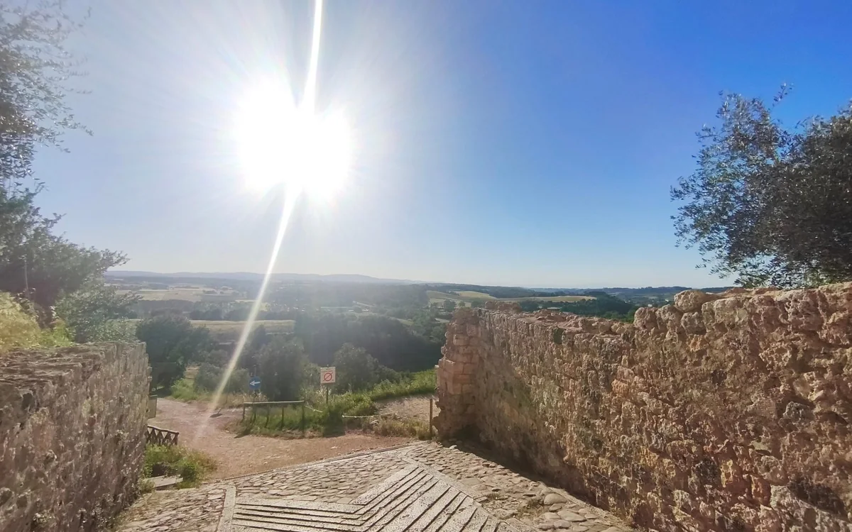 A stone terrace looking over sunlit Tuscan countryside